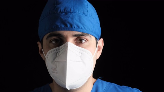 沉思疲倦的年轻男性医疗工作者戴着n95防护面罩看着摄像机视频素材
