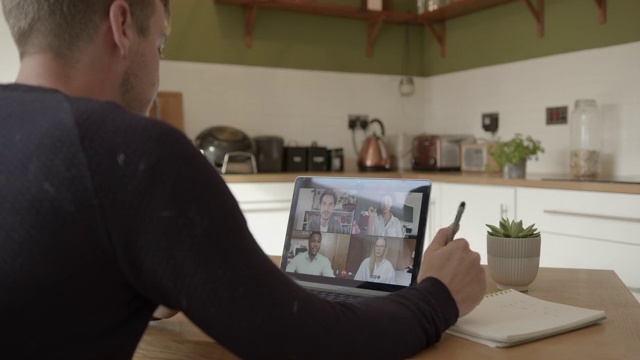 男性在家使用笔记本电脑技术在餐桌前工作视频素材