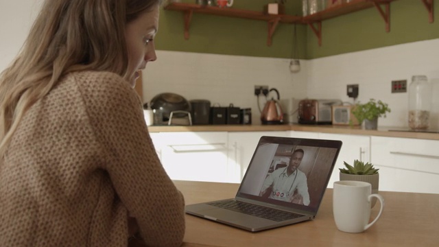 疫情期间，在厨房通过笔记本电脑进行视频通话的女性医生视频素材