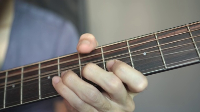 吉他手用左手按弦到乐器的颈部。视频素材