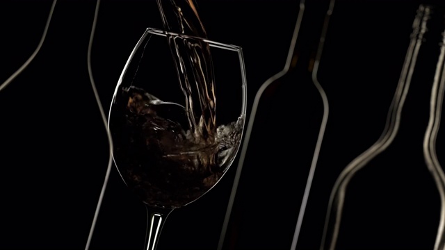 葡萄酒倒入酒杯。深色背景，瓶子轮廓视频素材
