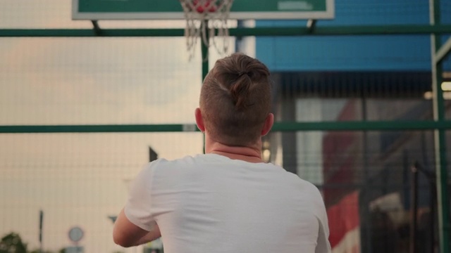 男人正在篮球场上把球扔进篮筐里视频下载