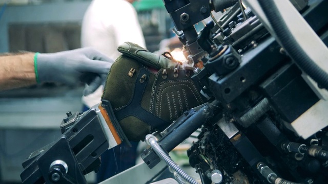工厂工人用机器塑造鞋子。眩光视频下载