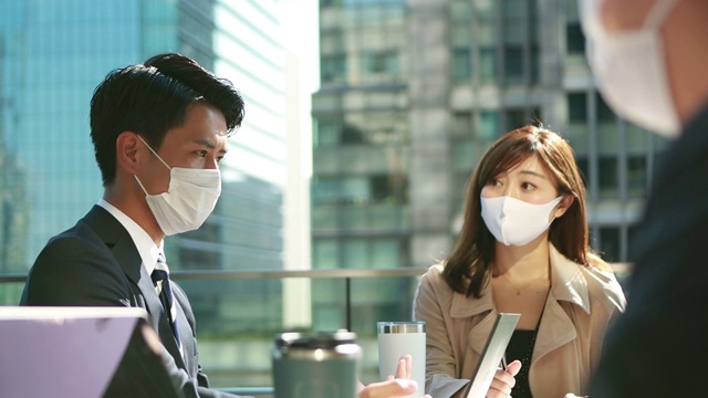 在亚洲，商务人士开会时要戴着防护面具保持社交距离视频素材