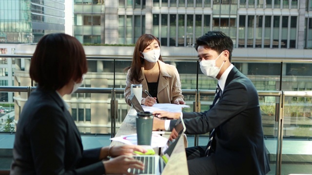 在亚洲，商务人士开会时要戴着防护面具保持社交距离视频下载