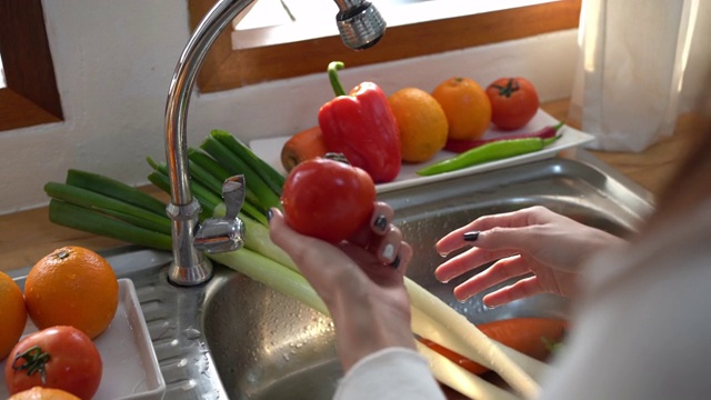 woman washing a fruit or vegetables in kitchen视频素材