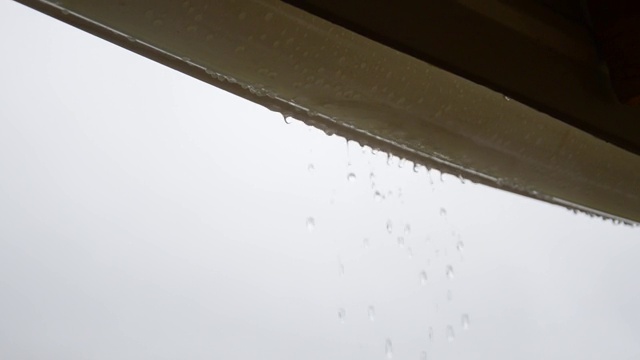 雨滴从屋顶滴落到桶里视频素材