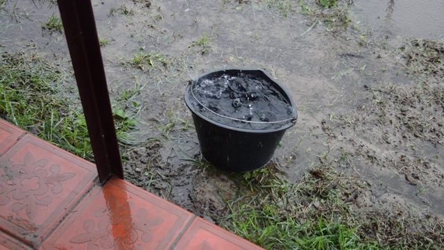 雨滴从屋顶滴落到桶里视频素材
