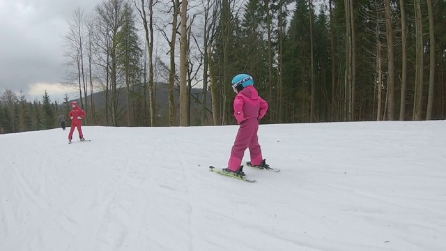 这孩子跟着教练学滑雪。视频素材