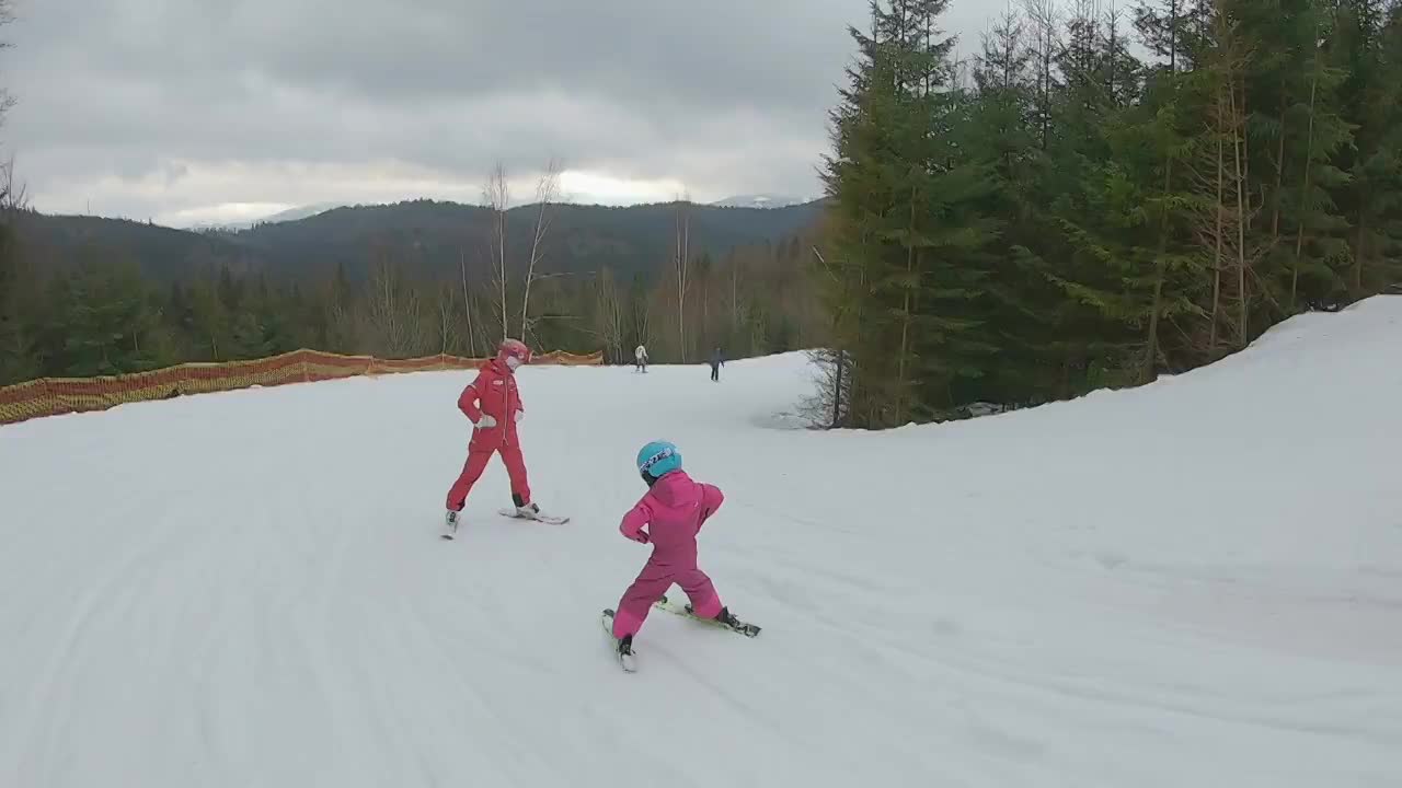 这孩子跟着教练学滑雪。视频素材