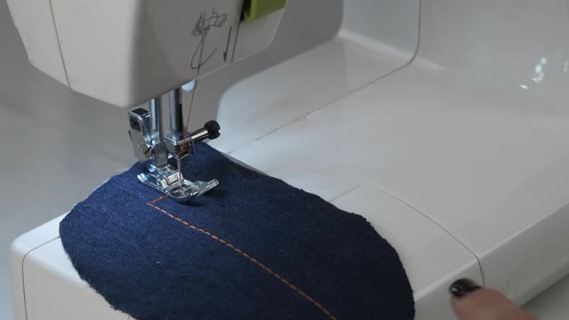 裁缝缝制牛仔裤。织物上的一个缝视频下载