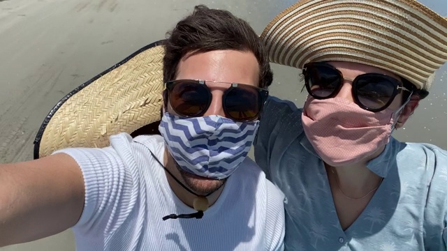一对年轻的夫妇在巴西的沙丘上拍摄虫子(小马车)之旅-使用面罩-摄像机的视角视频下载