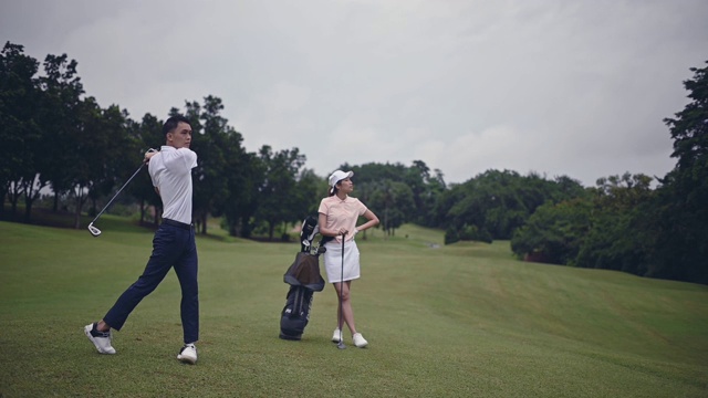 亚洲华人男性高尔夫球手在高尔夫球场上开球并挥动他的驾驶杆视频素材