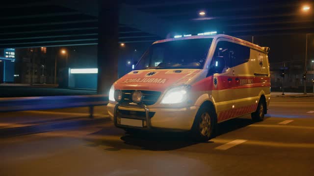 并行移动的视频与工作频闪灯和信号驾驶紧急呼叫在城市城市街道上的夜晚。有医疗十字标志的急救人员救援车。视频下载