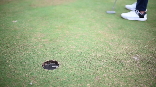亚洲华人男子高尔夫球击到高尔夫球场的高尔夫洞的特写镜头视频素材