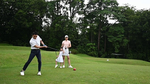在高尔夫球场上，一对年轻的亚洲华人高尔夫选手开球并挥杆视频素材