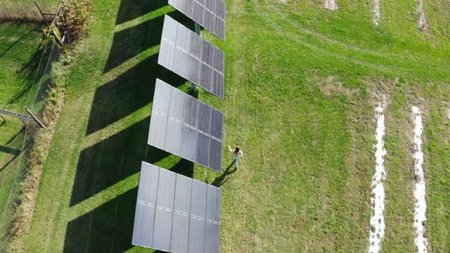 在农场的太阳能电池板旁行走的女人视频下载