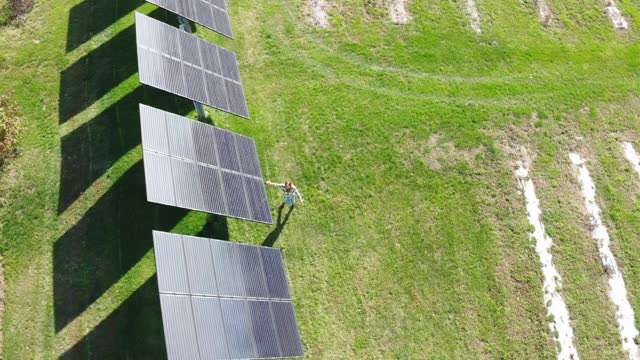 在农场的太阳能电池板旁行走的女人视频素材