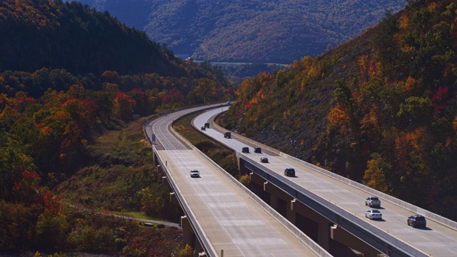 落在山上。飞越宾夕法尼亚收费高速公路的高桥。航拍视频与向前摄像机运动视频素材