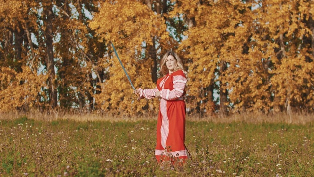 中世纪的概念-妇女在红色民族长连衣裙旋转剑周围自己视频下载