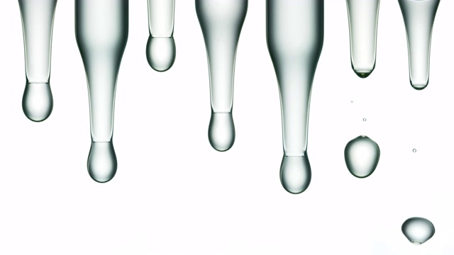 近距离和慢动作的液体滴从七个实验室移液管放置在一排白色背景视频素材