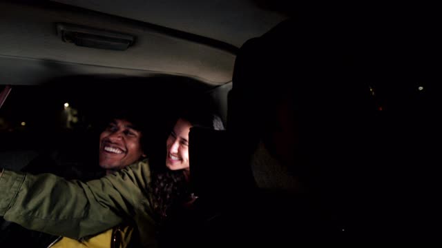 年轻人晚上在车里用智能手机自拍视频素材
