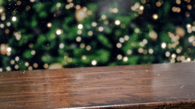 木制桌面抽象模糊圣诞树与串光和雪花背景与散景灯，冬季假日背景，模拟横幅展示产品或促销视频素材