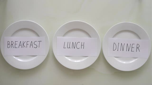 一位妇女用禁食代替了盘子上的早餐、午餐和晚餐。间隔禁食的概念。不吃饭视频下载