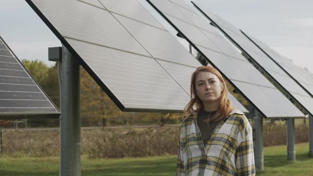 一名年轻女子走在太阳能电池板旁边视频素材