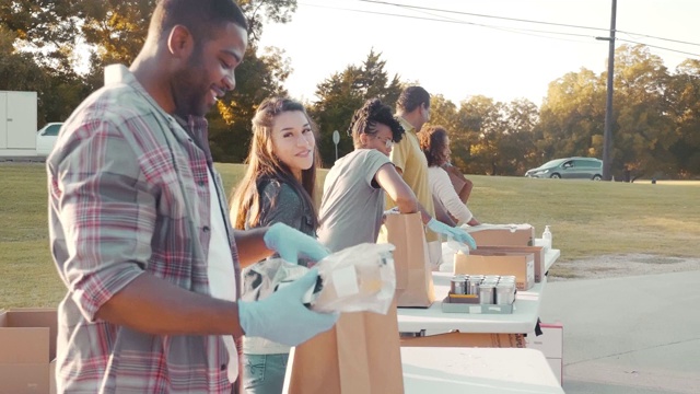 在食物募捐活动中，快乐的志愿者们一起工作视频素材
