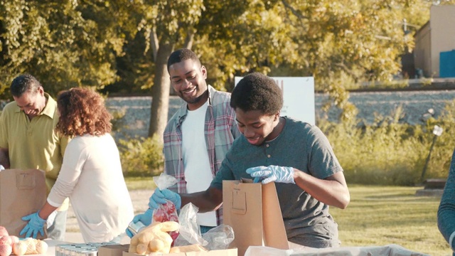各种志愿者在户外食物捐赠活动中整理食物视频素材