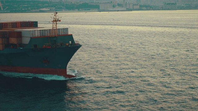 在伊斯坦布尔博斯普鲁斯海峡，无人机拍摄到海豚在货轮前跳跃视频素材