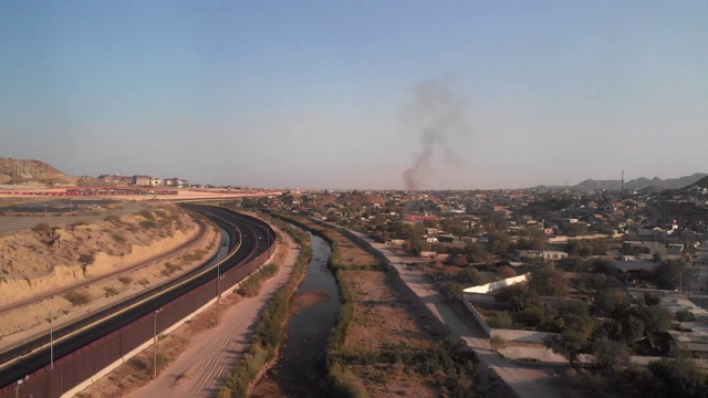 美国和墨西哥之间的国际边界隔离墙或围栏在德克萨斯州的埃尔帕索和Ciudad Juárez, Chihuahua墨西哥黄昏视频下载