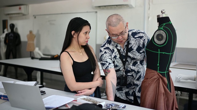 亚洲大学时装专业的学生正在教室里学习他们的时装设计视频下载