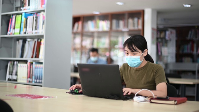 在图书馆学习的亚洲大学生观察社会距离视频下载