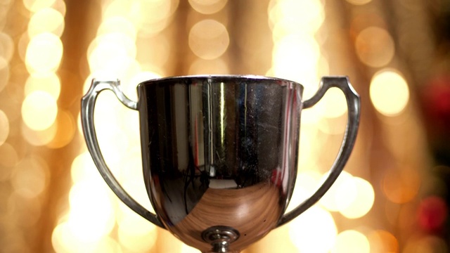 银质奖杯与圣诞灯光背景，胜利的概念。视频下载