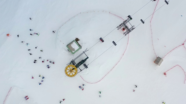供滑雪者及滑板者在雪上滑雪时使用的滑雪缆车鸟瞰图。无人机飞过升降椅。滑雪胜地。滑雪电梯索道，供人们在冬季登山运输。视频素材