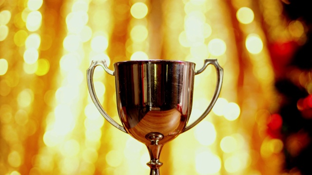 银质奖杯与圣诞灯光背景，胜利的概念。视频下载