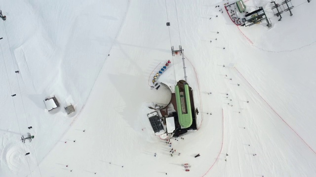 供滑雪者及滑板者在雪上滑雪时使用的滑雪缆车鸟瞰图。无人机飞过升降椅。滑雪胜地。滑雪电梯索道，供人们在冬季登山运输。视频素材