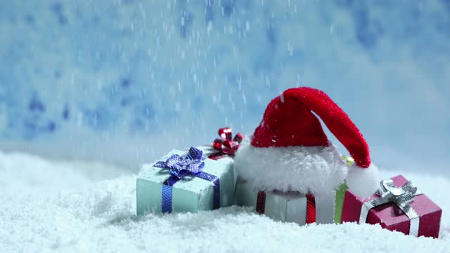 圣诞老人的帽子和礼物在雪中视频素材