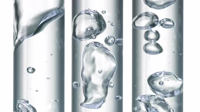 近距离和超级缓慢的运动，清水冒泡倾倒在三个清晰的移液管在白色的背景视频素材