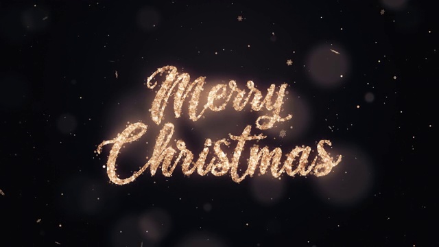 手写的圣诞快乐文字与金色闪光在黑暗的背景。视频素材