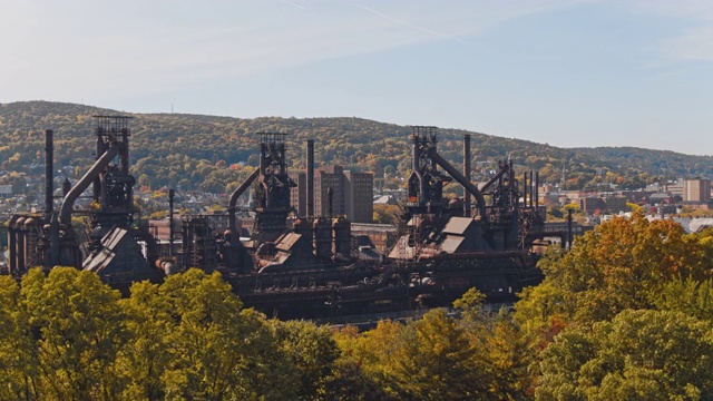 钢铁大厦——历史悠久的钢铁厂，曾经被遗弃，但现在被改造成宾夕法尼亚州伯利恒的现代文化中心。带前向摄像机的无人机视频在树顶上方。视频素材