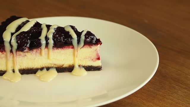 焦糖芝士蛋糕。焦糖酱淋在以草莓装饰的经典芝士蛋糕上。视频素材