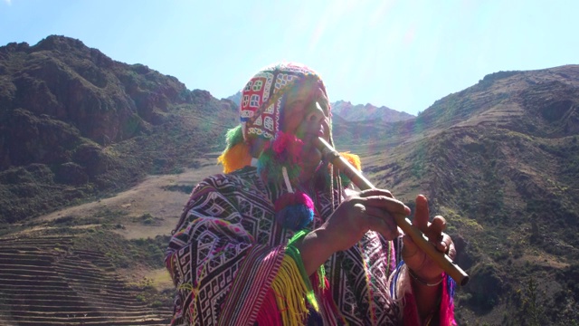 老人穿着秘鲁传统服装，吹着笛子视频下载