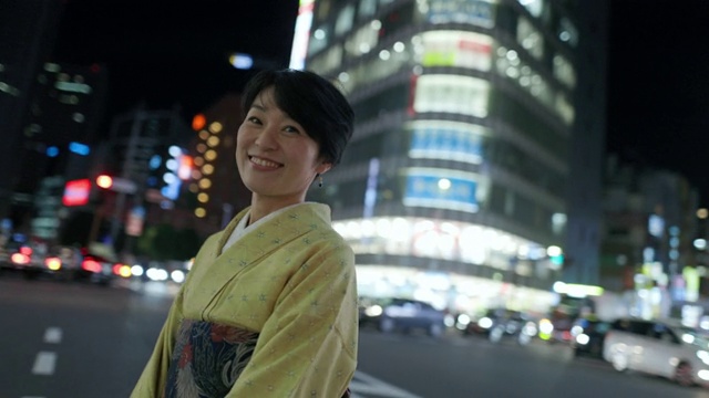 身着和服的日本妇女站在夜间城市的斑马线上视频下载