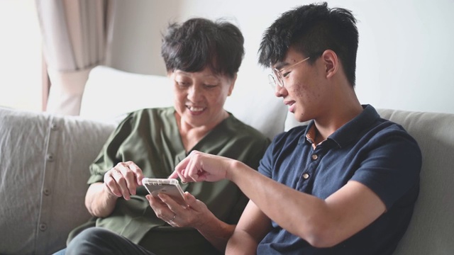 亚洲华人高级妇女看她的手机检查信息社交媒体上网冲浪视频素材