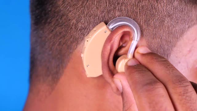 助听器概念，一个听力有问题的年轻人。视频下载