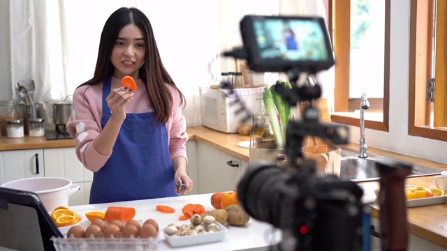 亚洲年轻女性录制视频食物。视频下载
