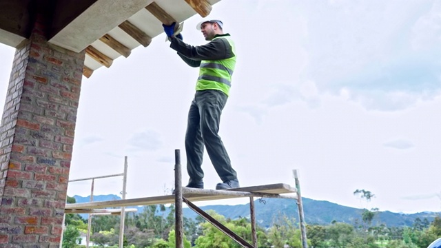建筑工人正在采取一切保护措施修理屋顶视频下载